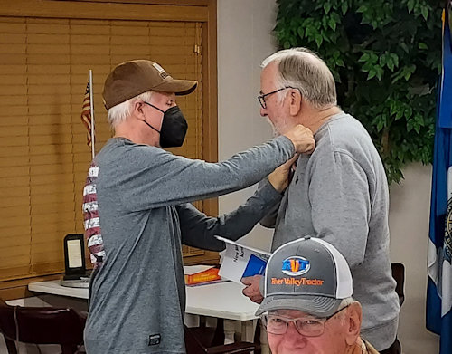 New Compatriot John Kelsey receives a SAR Member Rosette from Registrer Dennis Beckham.