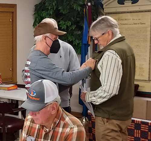 New Compatriot Larry Chandler receives a SAR Member Rosette from Registrer Dennis Beckham.