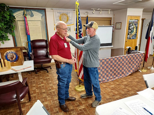 Registrar Dennis Beckham pins his roset on new member Edward Wendell Van Hook after swearing him into the SAR.