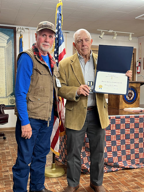 Registrar Dennis Beckham presents the Military Service Medal to Compatriot Pat Tomberlain.